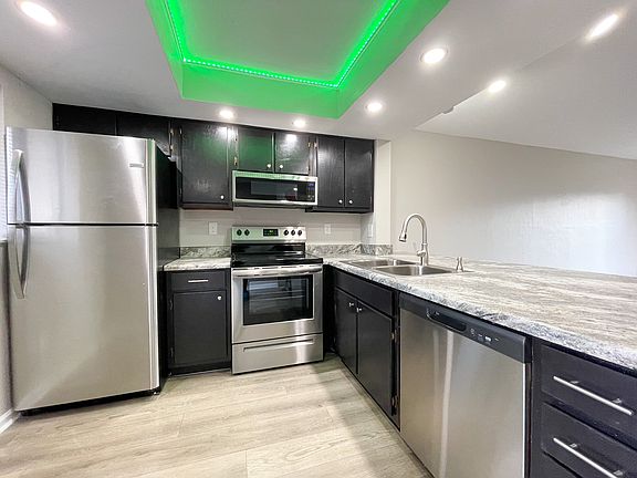 Chef-inspired kitchen with stainless steel appliances and a color-changing ceiling light.