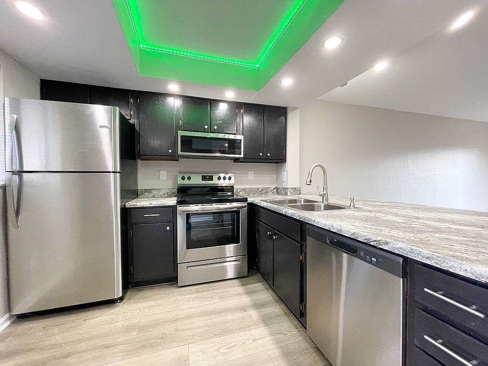Chef-inspired kitchen with stainless steel appliances and a color-changing ceiling light.