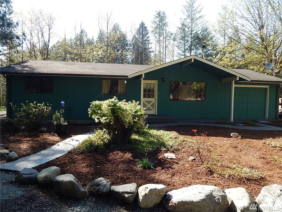 Front of home with stamped walkways and covered front porch area. One car garage and additional carport area to the right.