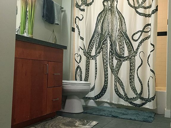 Tiled bathroom with tub / shower.