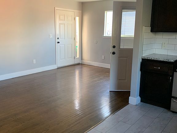 Entry door to the left and open door with glass in entrance to laundry room