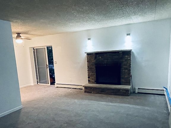 Partial view of living room/dining room area taken from front door (more to come tomorrow); the fireplace works. The new carpet is a light grey; walls are painted in eggshell white with a tinge of grey.