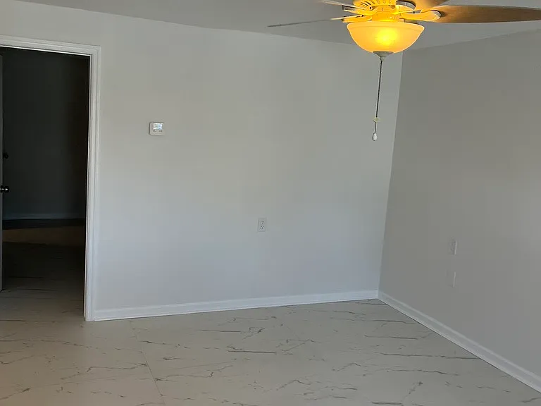 Looking from the front door to the bedroom. New tile floors with marble like appearance.