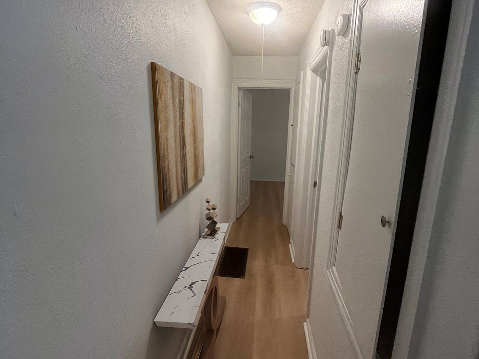 Hallway from the living room to the kitchen on the right, bathroom, and bedroom at the end