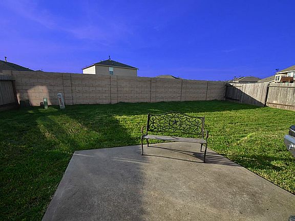 Small concrete patio in the backyard, perfect for a small seating area.