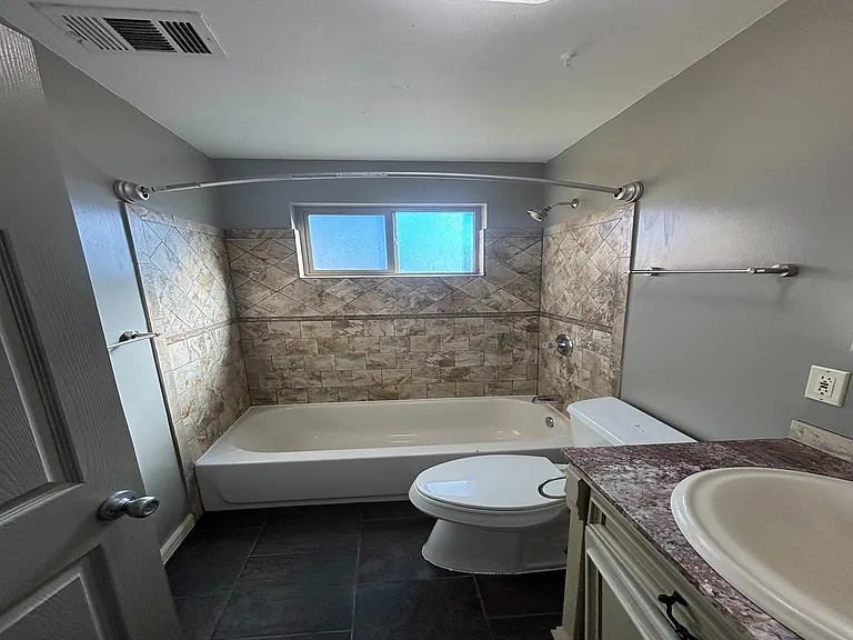 Charming bathroom with elegant tilework, modern fixtures, and natural light through a frosted window.