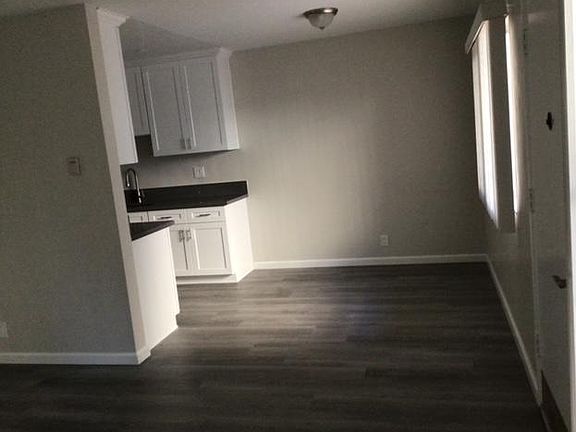 Dining room and kitchen from front room, front door on the right.