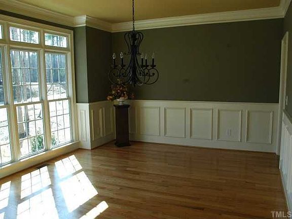 le dining room with loads of light and detailed wainscoting.