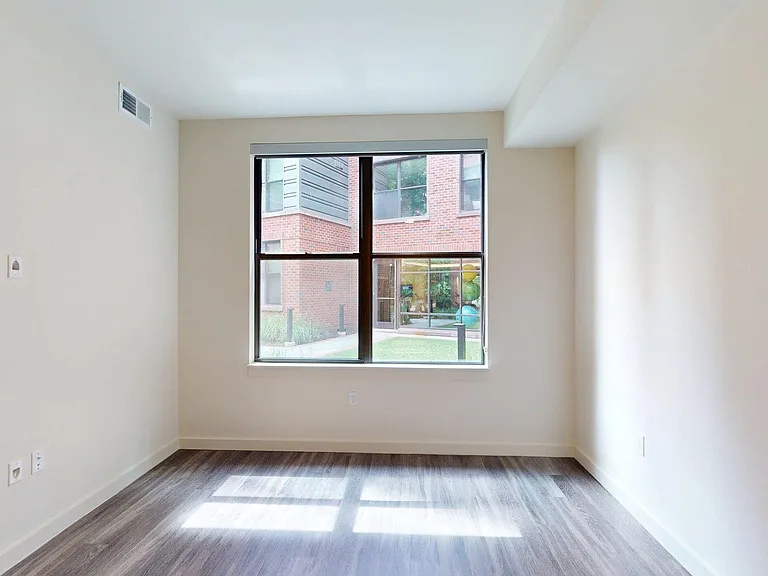 Spacious bedroom with large closet and wood-style flooring.