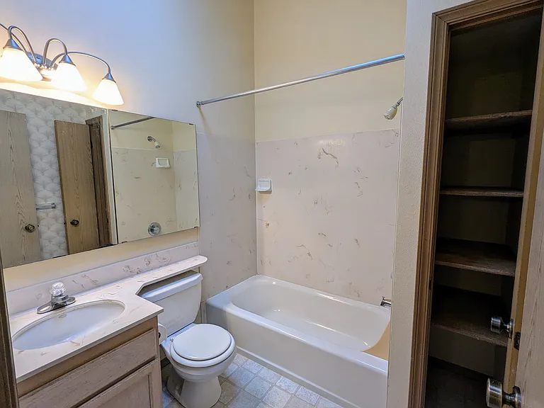 Full bathroom with vaulted ceiling and skylight, large linen closet