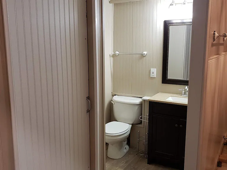 Toilet & vanity room to the left of tub room inside a door that closes.