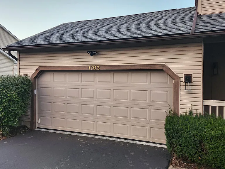 This siding will be replaced shortly by nice, gray/blue siding with off-white trim, carbon black gutters and shutters, and pastel mint green doors. I'm still in the design phase! There's a Ring floodlight camera above the garage as well.