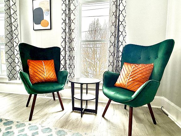 These chic and comfortable accent chairs add a touch of style and elegance to the living room, offering a cozy spot to relax and enjoy the bright, airy space.