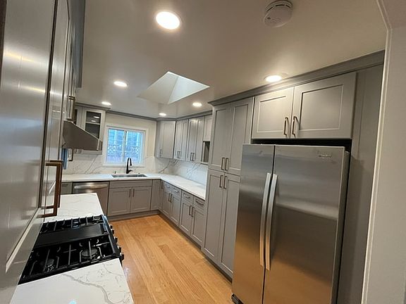 Bright airy kitchen with broad window and skylight
