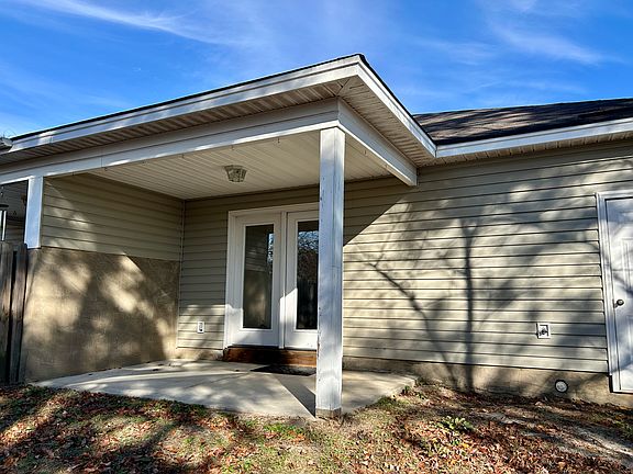 Back covered patio and outside storage closet with hot water heater.
