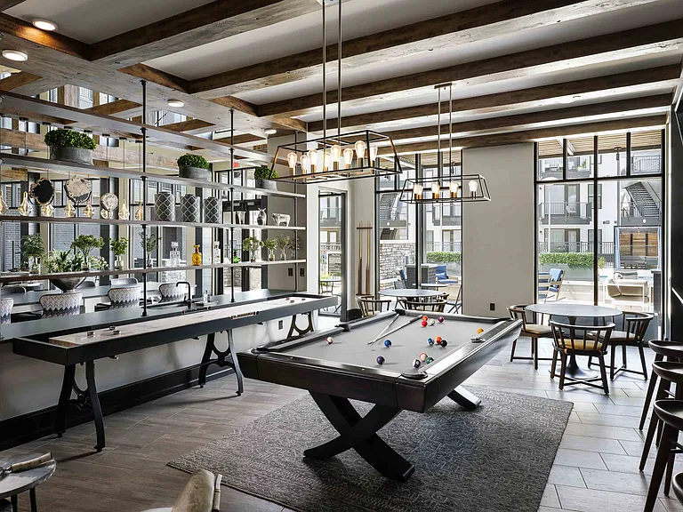 Entertainment lounge with pool table, games, and TVs