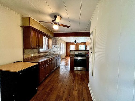 View of kitchen, looking toward living room, from back bedroom doorway. Dishwasher on left.