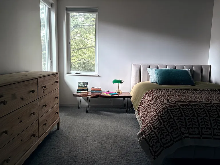 Second floor bedroom overlooking the backyard. A queen size bed is shown. This room also has a closet.