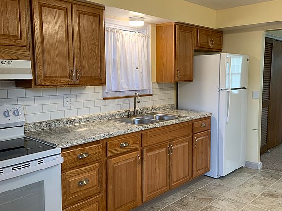 LARGE KITCHEN WITH PORCELAIN TILE FROM ITALY. SOLID OAK CABINETS, NEW APPLIANCES INCLUDE ELECTRIC RANGE, EXHAUST FAN & GE REFRIGERATOR
