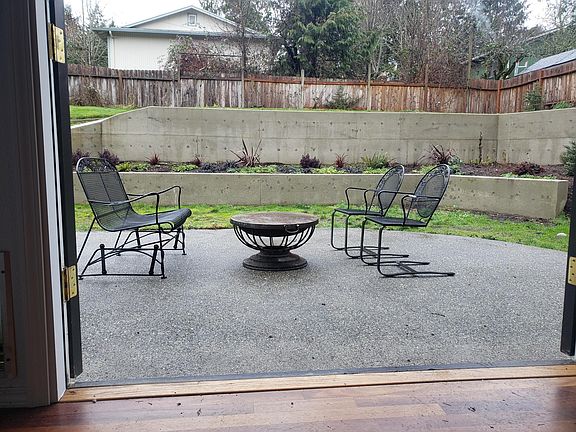 French doors from the dining room open to the fenced backyard with a large patio and terraced yard. A lower retaining wall is designed to be comfortable seated height.