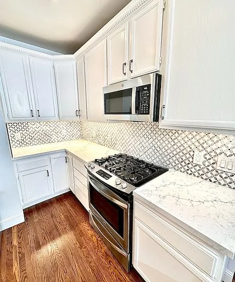 Unit #504 stunning chefs kitchen with marble countertops custom backsplash and stainless steel appliances including gas stove!