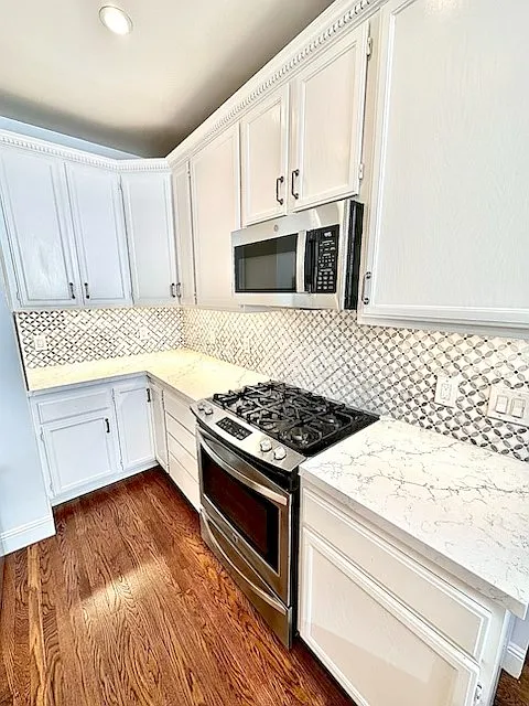 Unit #504 stunning chefs kitchen with marble countertops custom backsplash and stainless steel appliances including gas stove!