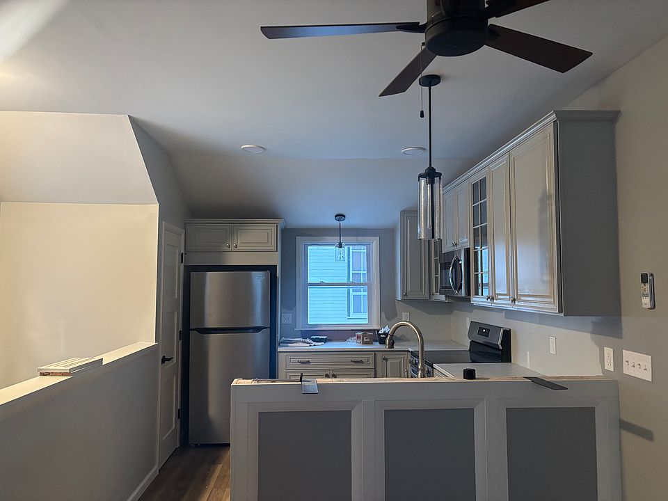 Kitchen with Breakfast bar as viewed from living room with staircase on left.