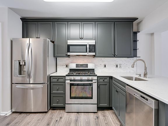 Renovated kitchen with quartz counters, stainless steel appliances and gas cooking