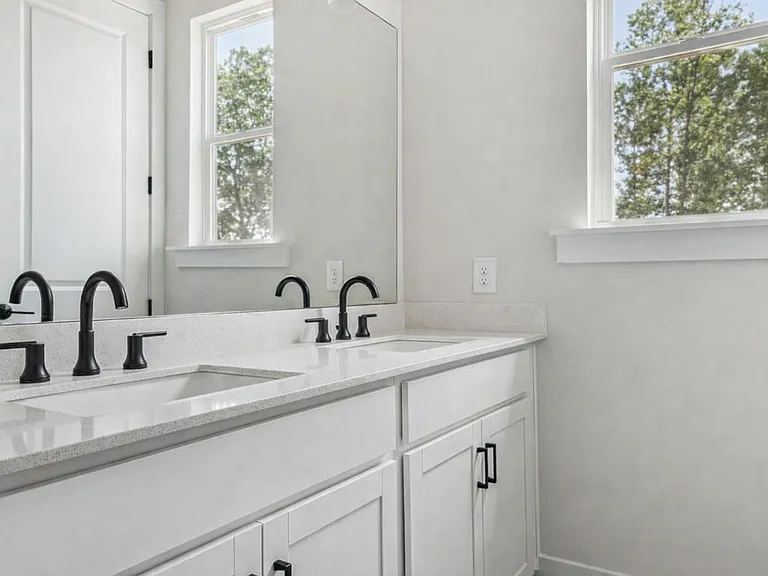 Primary bathroom double vanity with natural light