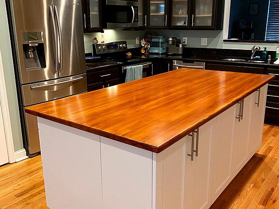 Kitchen with island for additional storage and pull out trash and recycling cabinet.