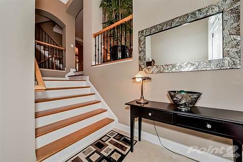Upon entering the townhome, you are greeted by a warm two-story entrance foyer with a powder room to the left and an intermediate landing with hardwood stairs leading you into the living room.