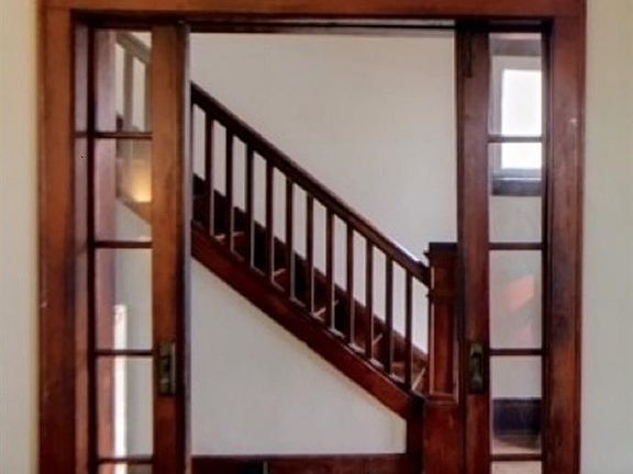 View of entry way with original beautiful glass-paned pocket doors.