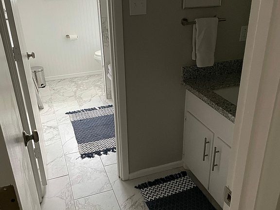 Fully updated hall bath with new tile, granite countertops and updated tub/shower