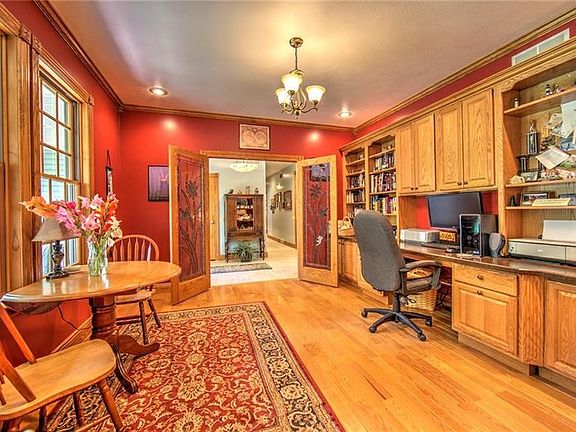 13x13 Home Office/Den with plenty of natural light, built in desk, cabinetry, and shelving.  Double leaded glass doors lead to t