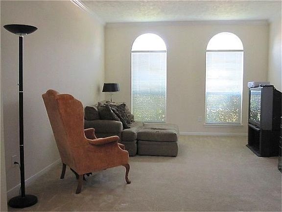 The formal living room is on the right as you enter the home.  It has elegant window design, neutral carpet and wall colors, and decorative crown molding.
