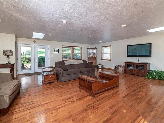LIVING ROOM, 25X23, WITH PELLA DOORS OPENING TO COVERED PATIO AREA WITH DRY-STACK STONE OUTDOOR KITCHEN AREA.