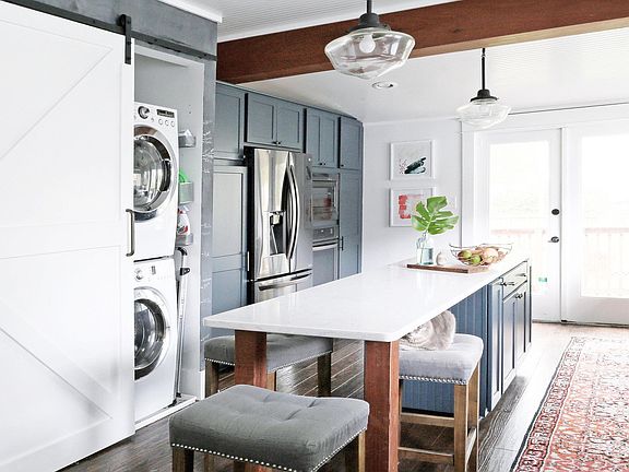 Stackable Laundry hidden behind a sliding door in kitchen