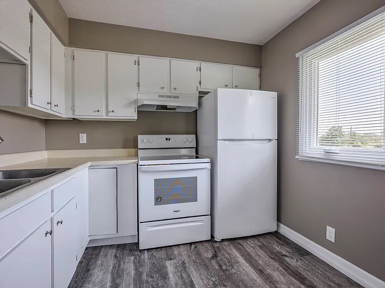 Kitchen with white appliances at Ashland Park Apartments.