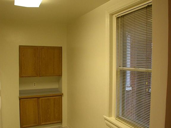 kitchen, more cabinets in the rear, and a window