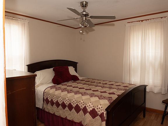 Bedroom off living room. Tall antique Bureau and night stand.