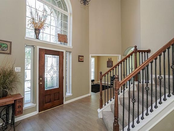 Leaded glass front door with side lights. The wood look tile starts at the entry.
