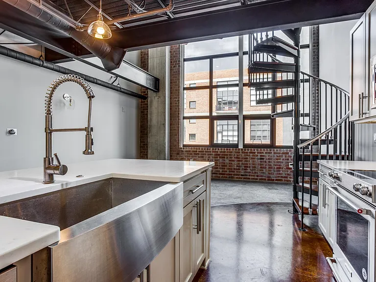 Cook in style in a chic galley kitchen featuring a modern farmhouse sink, quartz countertops, and high-end KitchenAid appliances, making culinary dreams a reality.