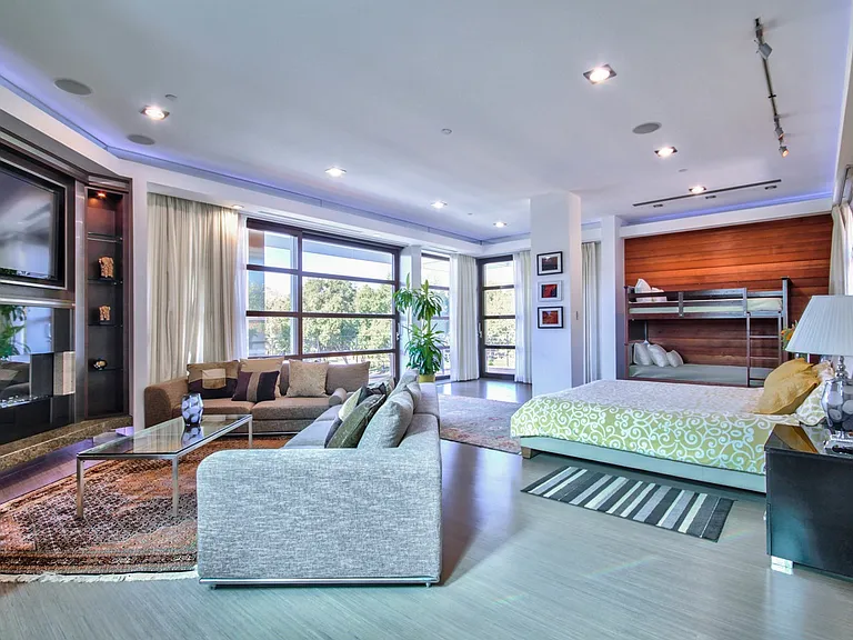 master bedroom seating area with large TV and gas fireplace