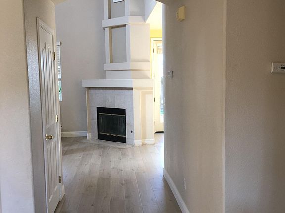 Hall to Family Room with Fireplace and Kitchen