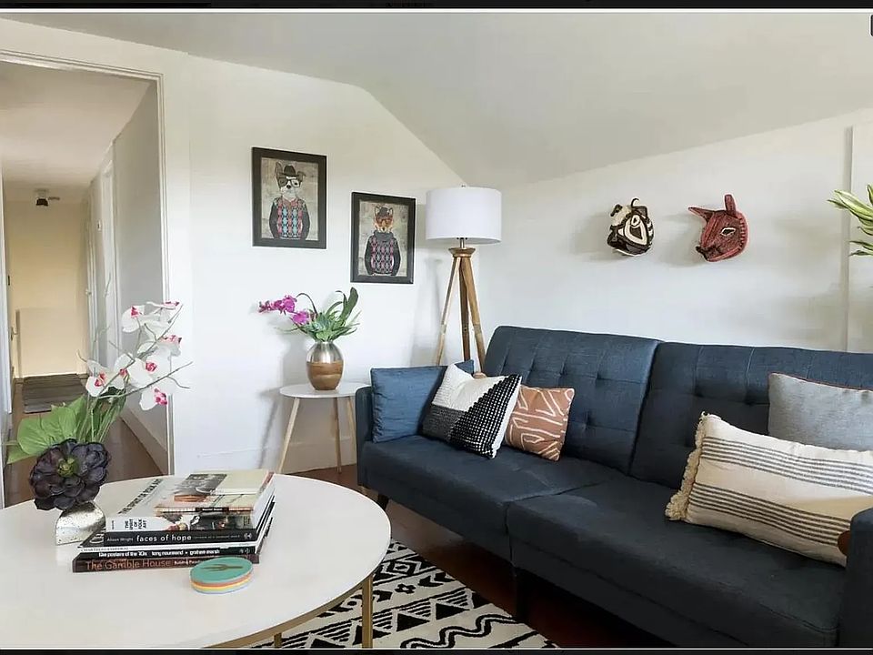 View of the airy living room, which features hardwood floors, elegant arches in the ceiling, and two storage closets.