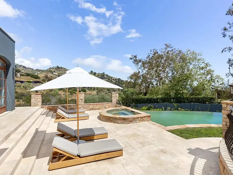 Lounge poolside on the teak loungers with umbrellas.