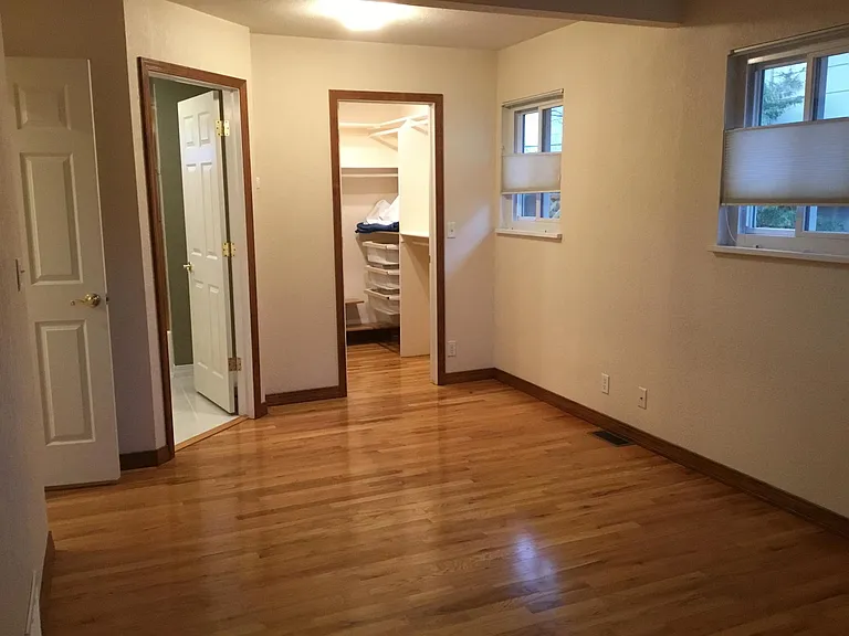 walk in closet, primary bathroom and lovely wood floors in bedroom