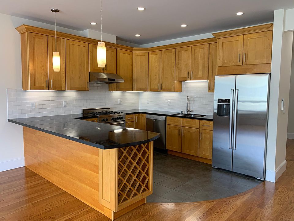 Immaculate kitchen with stainless steel appliances including dishwasher and wine storage.