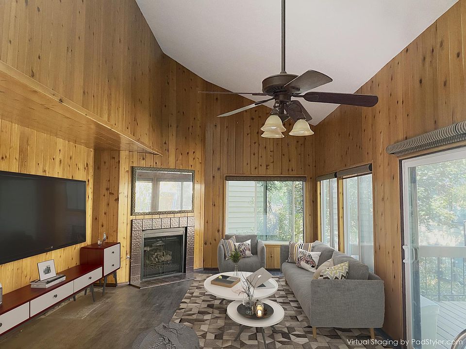 Cozy living room with vaulted ceiling and knotty cedar paneling