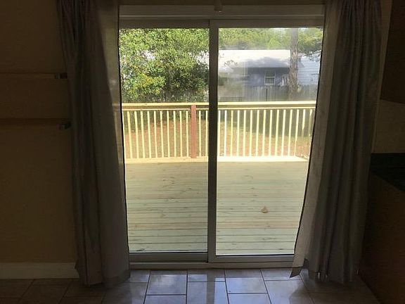 Sliding door from dining area out to large raised deck & backyard